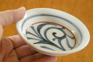 砥部焼・梅山窯 赤線からくさの小皿を手に持って