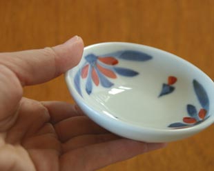 砥部焼・梅山窯 花もようの小皿(3寸)を手に持って