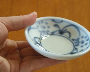 砥部焼・梅山窯 太陽柄の小皿を手に持って