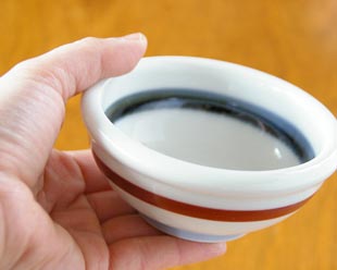 砥部焼・梅山窯 朱線の玉ぶち鉢(3寸)を手に持って