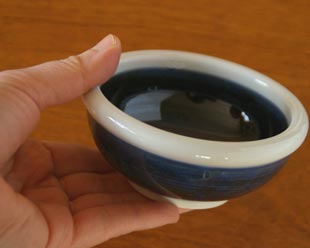 砥部焼・梅山窯 藍色の玉ぶち鉢(3寸)を手に持って