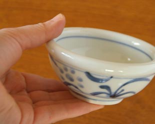 砥部焼・梅山窯 太陽柄の玉ぶち鉢(3寸)を手に持って