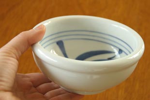 砥部焼・梅山窯 内からくさの玉ぶち鉢(4寸)を手に持って