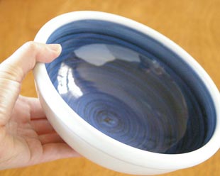 砥部焼・梅山窯 藍色の玉ぶち鉢(6寸)を手に持ったところ