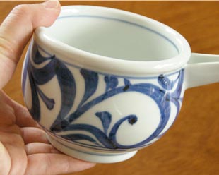 砥部焼・梅山窯 からくさの片口鉢(小)を手に持って