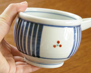 砥部焼・梅山窯 とくさみつ紋の片口鉢を手に持って