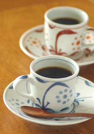 太陽柄と赤太陽のコーヒーカップにコーヒーを