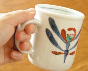 砥部焼・梅山窯 あか花のマグカップを手に持って