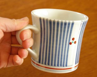 砥部焼・梅山窯　とくさみつ紋のマグカップを手に持って