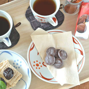 砥部焼・梅山窯 赤太陽のコーヒーカップのソーサーにお菓子を