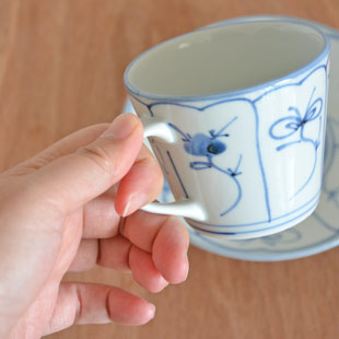 砥部焼・梅山窯 なずなのコーヒーカップを手に持って