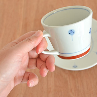 砥部焼・梅山窯 たんぽぽのコーヒーカップを手に持って