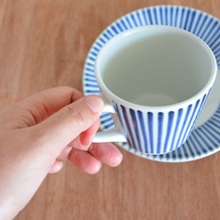 砥部焼・梅山窯 とくさ柄のコーヒーカップに紅茶をを手に持って