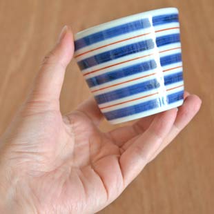 砥部焼・梅山窯 あい赤ラインのそばちょこを手に持って