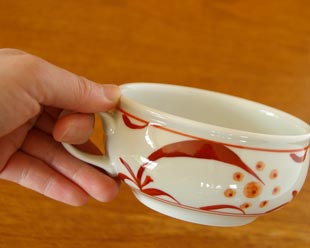 砥部焼・梅山窯 赤太陽のスープカップを手に持って