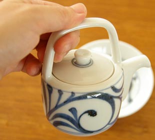 砥部焼・梅山窯 からくさの醤油さしを手に持って