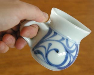 砥部焼・梅山窯 からくさの手付クリーマーを手に持って