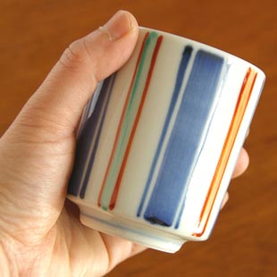 砥部焼・梅山窯 色絵模様の筒湯呑を手に持って