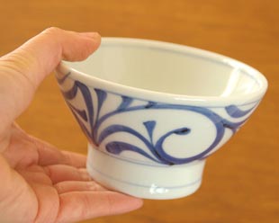 砥部焼・梅山窯 からくさの茶碗(小)を手に持って