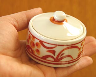 砥部焼・梅山窯 赤太陽の薬味入れを手に持って