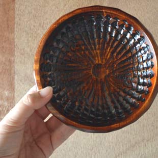 香川漆器 ハツリノミ彫の茶托を手に持って