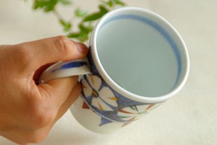 砥部焼・西岡工房 かざぐるまのマグカップを持ったところ