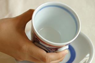 砥部焼 花からくさのコーヒーカップを手に持って