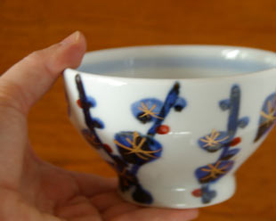 砥部焼・西岡工房　梅林の茶碗を手に持って