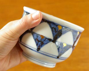 砥部焼・西岡工房 ゴスペン柄の湯呑を手に持って
