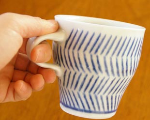 砥部焼・中田窯 はけめ模様のマグカップを手に持って