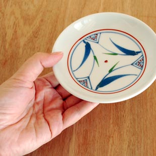 砥部焼・千山窯 上絵三方草の小皿(4寸)を手に持って