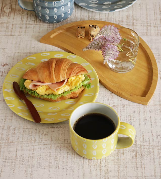 上から見たコーヒーの入ったマグカップとプレートの食卓