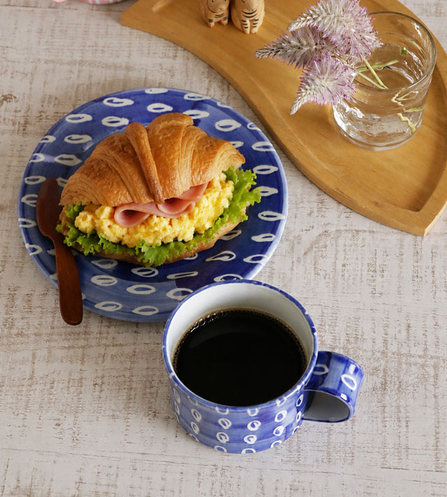上から見たコーヒーの入ったマグカップとプレートの食卓