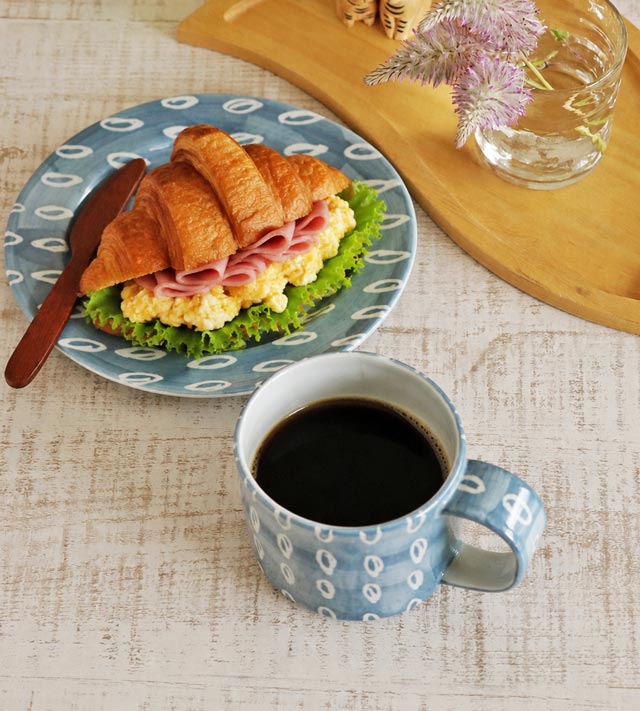 上から見たコーヒーの入ったマグカップとプレートの食卓