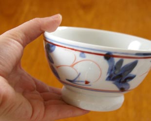 砥部焼・陶房遊　しだ紋の茶碗(小)を手に持って
