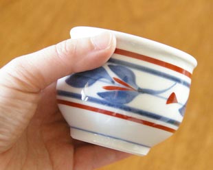 砥部焼・梅山窯 みつ葉の玉ぶち湯呑を手に持って