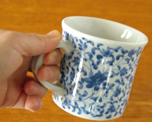 砥部焼・陽貴窯 菊唐草のマグカップを手に持って